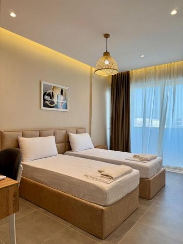a bedroom with two beds and a large window at Apartamente Antoni Shengjin2 in Shëngjin
