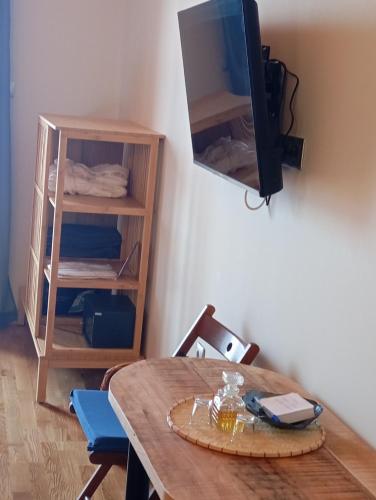 a dining room table with a television on a wall at Selana και Ielios Trikerisuites in Tríkeri
