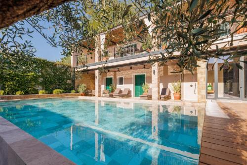 a swimming pool in the backyard of a house at Vila ROBIDA & SPA in Črni Kal