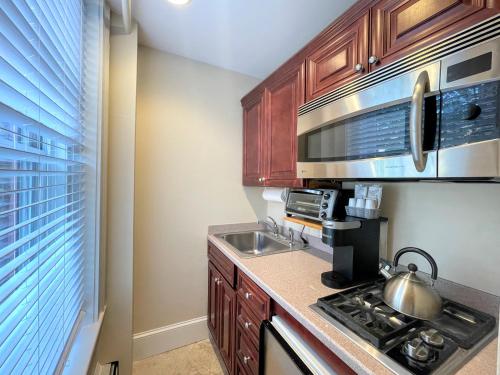 a kitchen with a stove and a sink and a microwave at Copley House in Boston