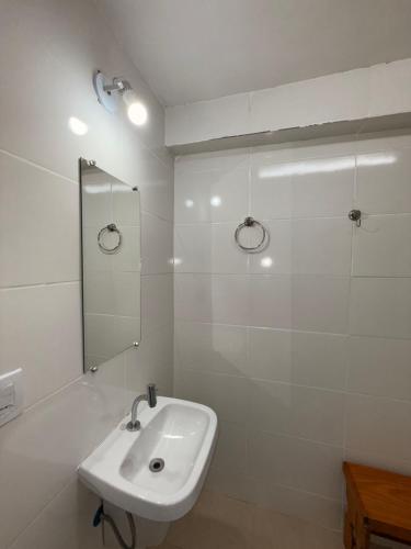 ein weißes Badezimmer mit Waschbecken und Spiegel in der Unterkunft Casa Encanto de Lavras Novas - MG in Lavras Novas