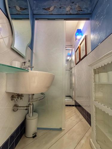 a bathroom with a sink and a glass shower at L'oblò in Riomaggiore