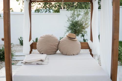 two pillows and a hat sitting on a bed at Villa Alba - Countryside Hideway Between Mostar & Blagaj 