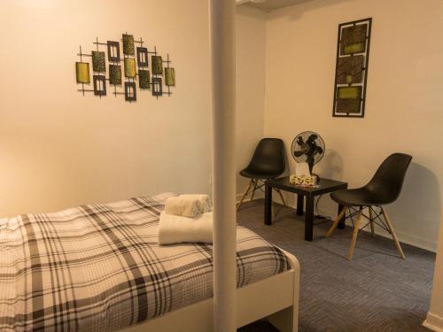 une chambre avec un lit, deux chaises et une table dans l'établissement Heart of MTR for Memerable Experiance 2 backyard 7minMetro Fully Renovated & Equipped, à Montréal