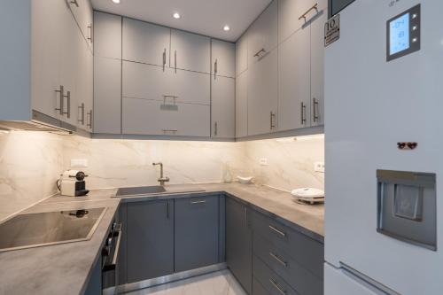 a kitchen with white cabinets and a sink at Villa Amantia in Kouvaláta