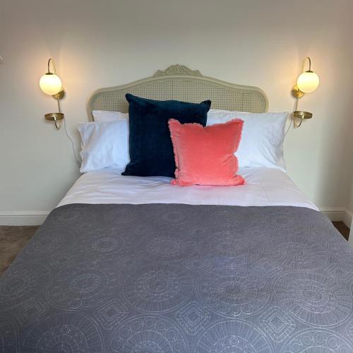 a bed with two pillows and a pink pillow on it at No 6 Harrogate Luxury Boutique Home in Harrogate