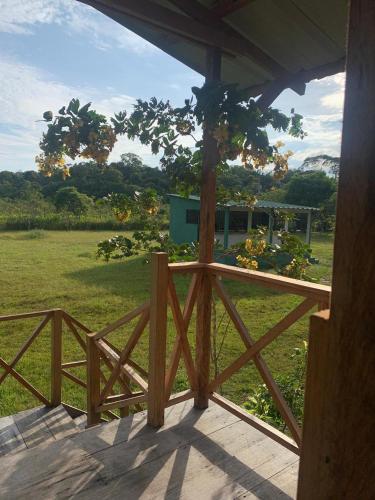 a porch with a wooden fence and a field of grass at El Nido in La Macarena