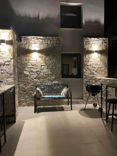 a room with a bench and a stone wall at Damari Luxury Retreat Villas Skiathos in Skiathos Town