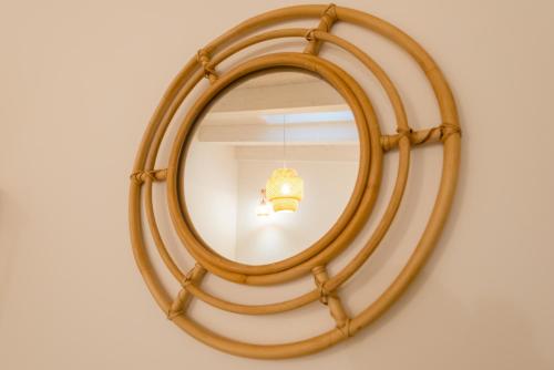 a round wooden mirror hanging on a wall at Just Relax Home in Le Casette