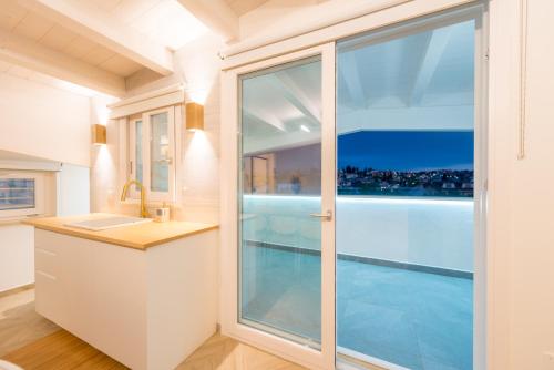 a kitchen with a sink and a sliding glass door at Just Relax Home in Le Casette