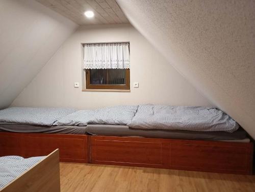 a bed in the corner of a room with a window at Novoveská chaloupka in Stříbrná