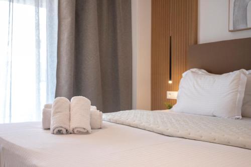 a bedroom with towels on a bed with a window at Unicos City Suites in Kos Town