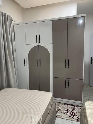 a bedroom with a bed and a large white cabinet at Eshyan Guest House in Aswan
