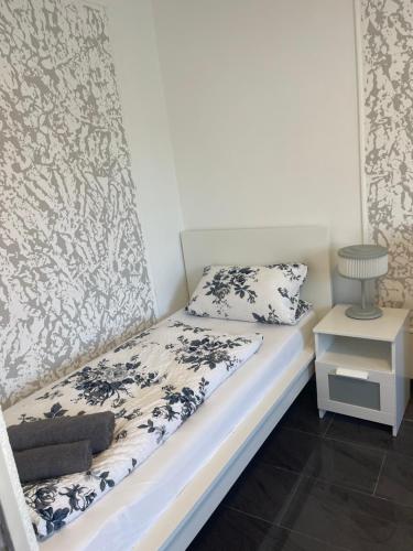 a small bedroom with a bed and a night stand at Hotel Shelby Apartments in Garbsen