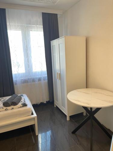 a room with a table and a bed and a cabinet at Hotel Shelby Apartments in Garbsen