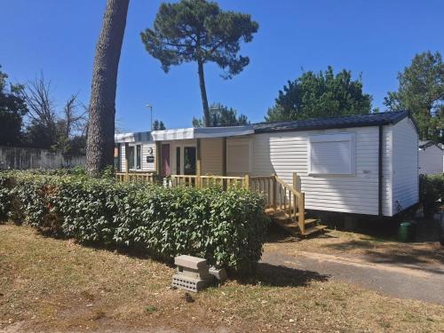 a tiny house with a porch and a tree at VICTORY-CELESTE 4 Places in Saint-Jean-de-Monts