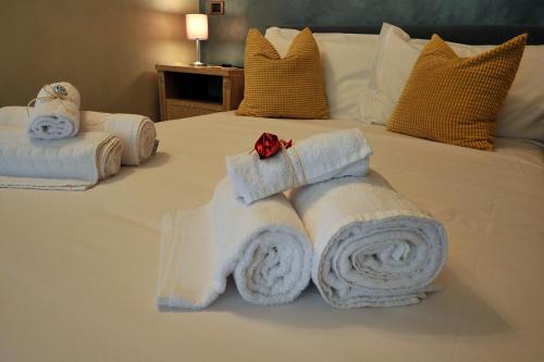 a bed with white towels and a red bow at B&B Casa di Giò Luxury Resort in Lanuvio