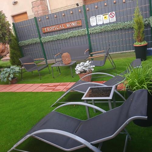 a group of chairs and tables in a yard at TROPICAL HOME PORTO CERESIO in Porto Ceresio
