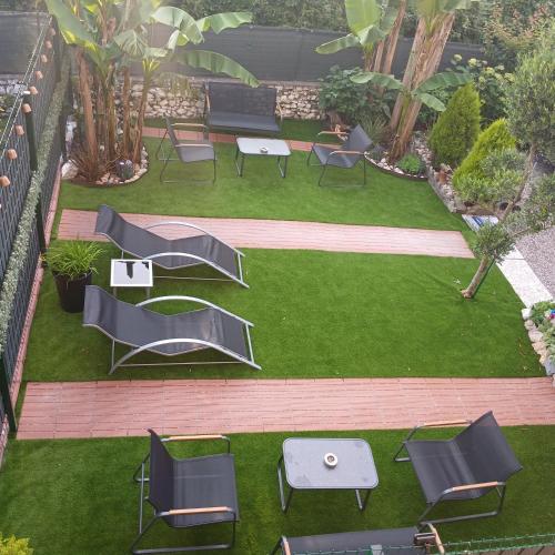 a group of chairs and tables on a lawn at TROPICAL HOME PORTO CERESIO in Porto Ceresio