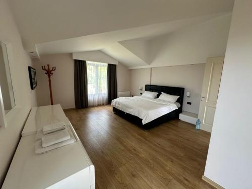 a bedroom with a white bed and wooden floors at Jon Private Vila 