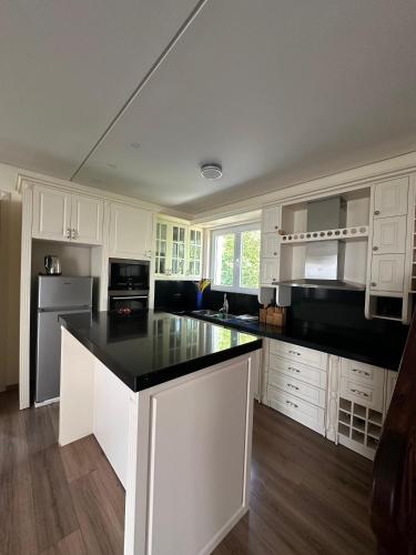 a kitchen with white cabinets and a black counter top at Jon Private Vila 