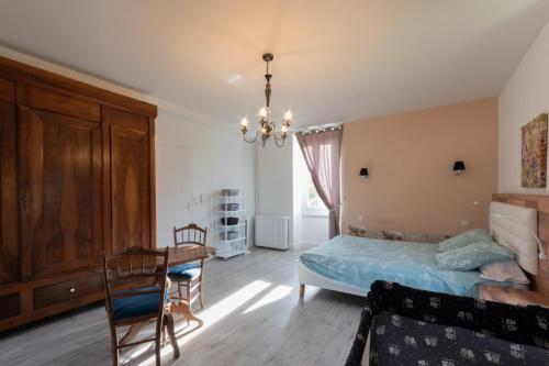 a bedroom with a bed and a desk and a table at La Maison du Soleil avec Jacuzzi 6p in Oloron-Sainte-Marie