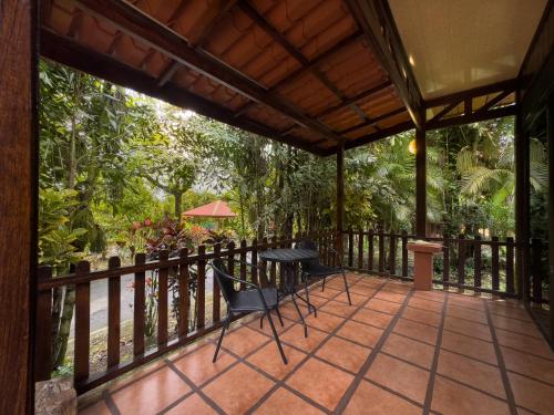 a patio with chairs and a table on a fence at Hotel Heliconias Nature Inn & Hot Springs in Fortuna