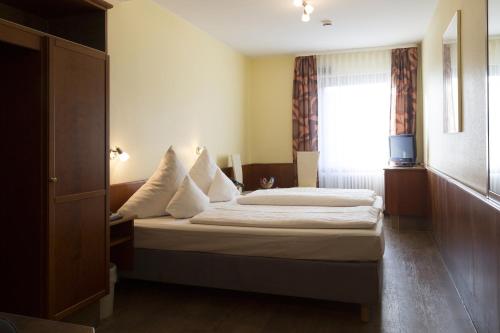 a hotel room with a bed and a window at TOP Hotel Amberger in Würzburg