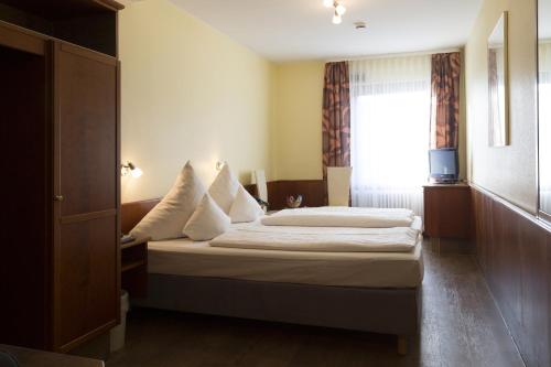 um quarto de hotel com uma cama e uma janela em TOP Hotel Amberger em Wurtzburgo