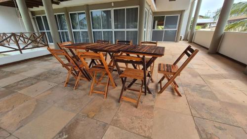a wooden table and chairs on a patio at Pousada Ceará - Porto das Dunas in Aquiraz