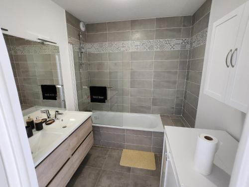 une salle de bain avec une baignoire blanche et un lavabo dans l'établissement Appartement Résidence Terra Cotta, à Toulouse