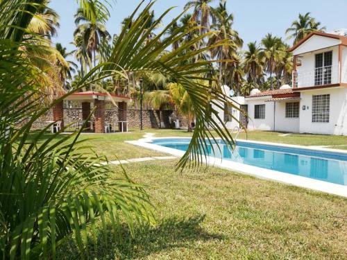 a villa with a swimming pool next to a house at Casa de 4 habitaciones con alberca in Barrio Nuevo