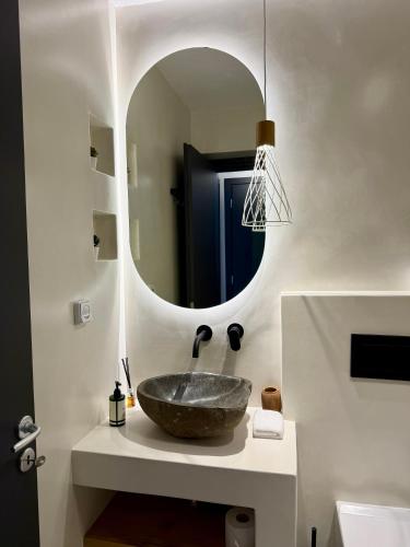 a bathroom with a stone sink and a mirror at Faragas Hill Oasis Villa in Angairiá