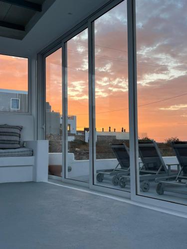 a view of the sunset from a house with windows at Acrothea Suites and Villas - Akrotiri Caldera - Santorini in Akrotiri
