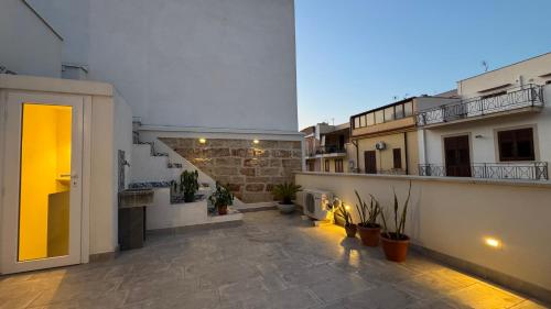 Un apartamento con un patio con plantas y un edificio. en Casarkeb, en Terrasini