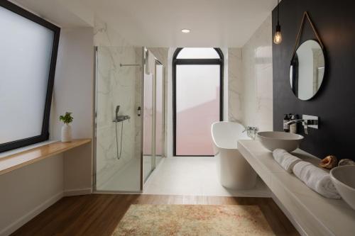 a bathroom with two sinks and a glass shower at Quinta do Rosário in Lagoa