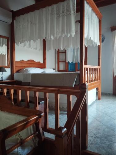 a bedroom with a bed and a wooden railing at Glaros Studios Agriolivadi Patmos in Patmos