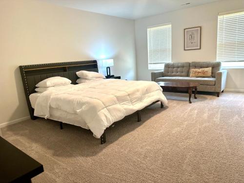 Un dormitorio con una cama, un sofá y una silla. en Beautiful Spacious Family-Friendly Home, en Winston-Salem