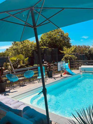 - un parasol au-dessus d'une piscine avec toboggan dans l'établissement Studio cosy à Royan, à Royan