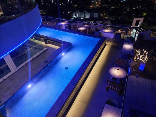 a swimming pool at night with lights at Hotel HBlue Malecón in La Paz
