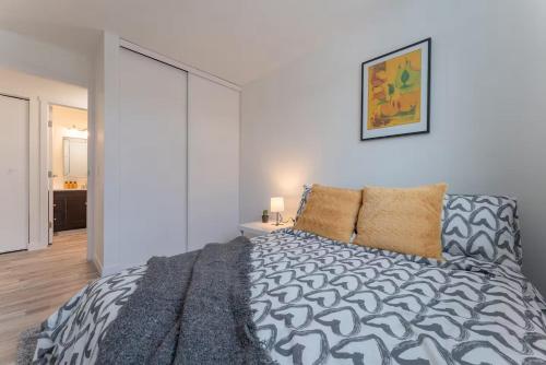 a bedroom with a bed with a black and white comforter at Private neat and cozy room with shared living room and kitchen in Calgary