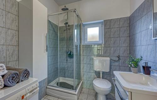 a bathroom with a shower and a toilet and a sink at Villa Lara, Family Retreat with Sea View & Pool in Sveti Filip i Jakov