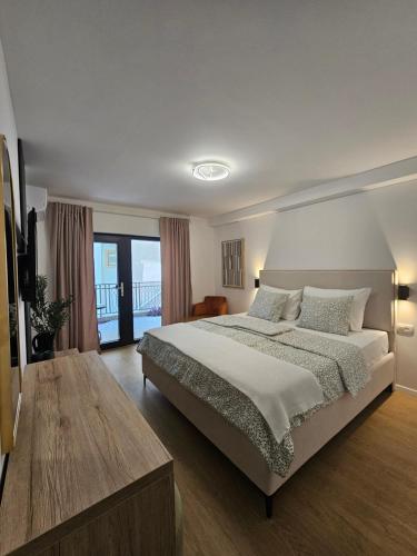 a bedroom with a large bed and a balcony at Lendas Apartments & Rooms in Baška Voda