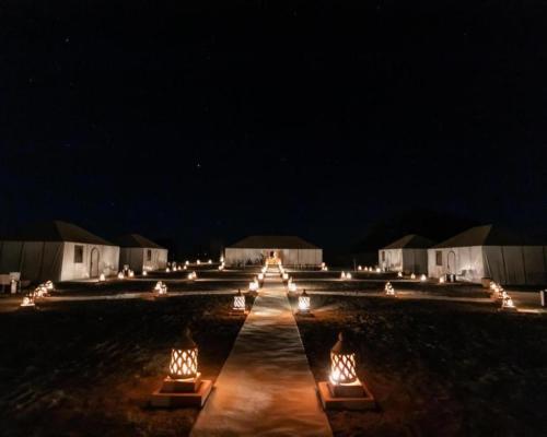 Una fila de luces en un campo por la noche en Africa Luxury Camp, en Merzouga