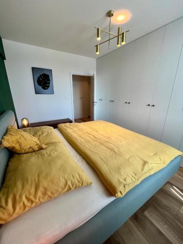 a bedroom with a large bed with a yellow blanket at Exclusive 2-room apartment in Nitra in Nitra