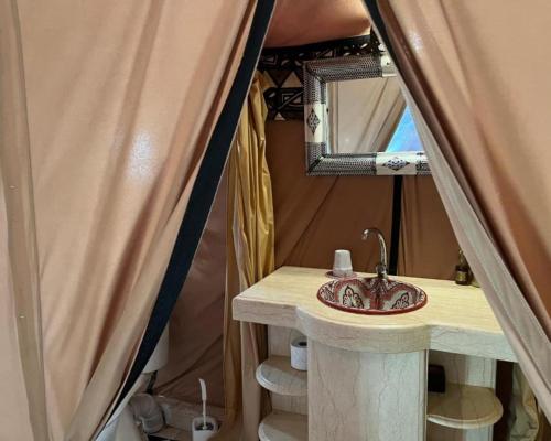 un baño con lavabo y espejo en Africa Luxury Camp, en Merzouga