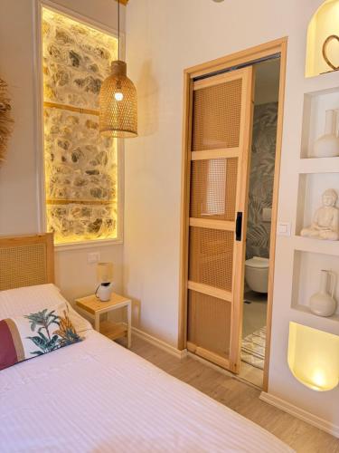 a bedroom with a bed and a window with a bathroom at Old Town Suites Muradie in Vlorë