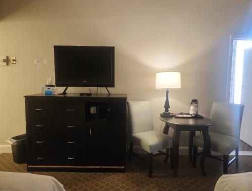 a hotel room with a television and a table and chairs at Natural Bridge Hotel, Trademark Collection by Wyndham in Natural Bridge