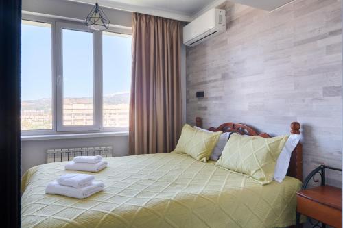 One Bedroom Apartment Next to Arbat In The Center of Almaty في ألماتي: غرفة نوم بها سرير عليه منشفتان