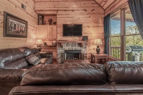 ピジョン・フォージにあるCozy Retreat in Smoky w Hot Tub & Pool Tableのリビングルーム(革張りのソファ、暖炉付)